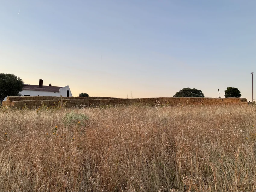straw walls shape amphitheater, experimental garden and walking path in rural spain - 2