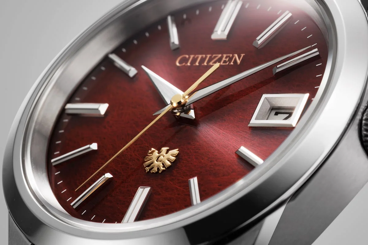 Close-up of the crimson AQ4100-65X dial showing the paper texture, gold-colored seconds hand and eagle