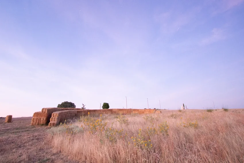 straw walls shape amphitheater, experimental garden and walking path in rural spain - 1